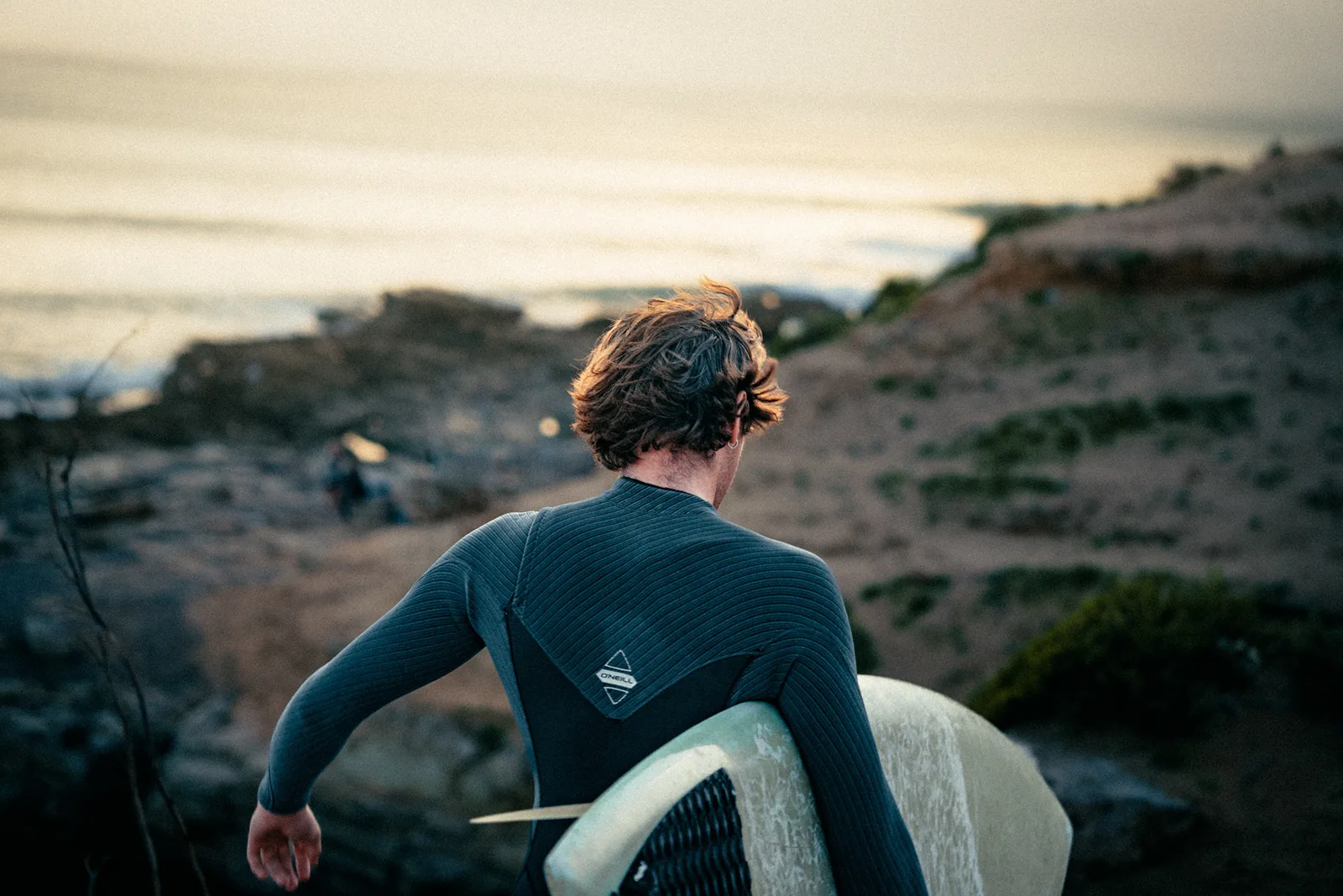 Windswept surfer gazing out at the ocean from a coastal bluff in Essaouira, Morocco