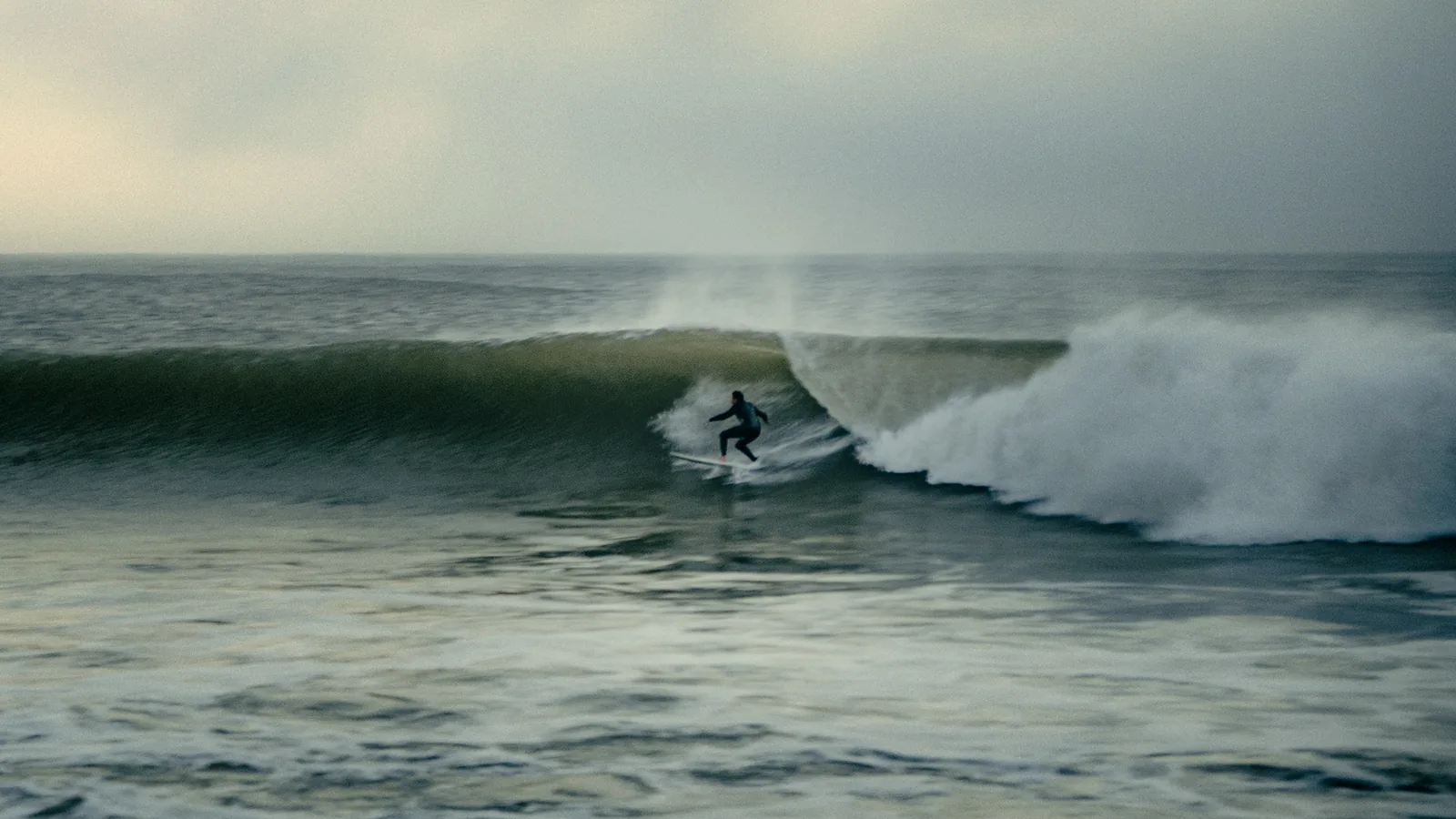 Surfer crouched deep inside a curling wave barrel off the coast of Essaouira, Morocco