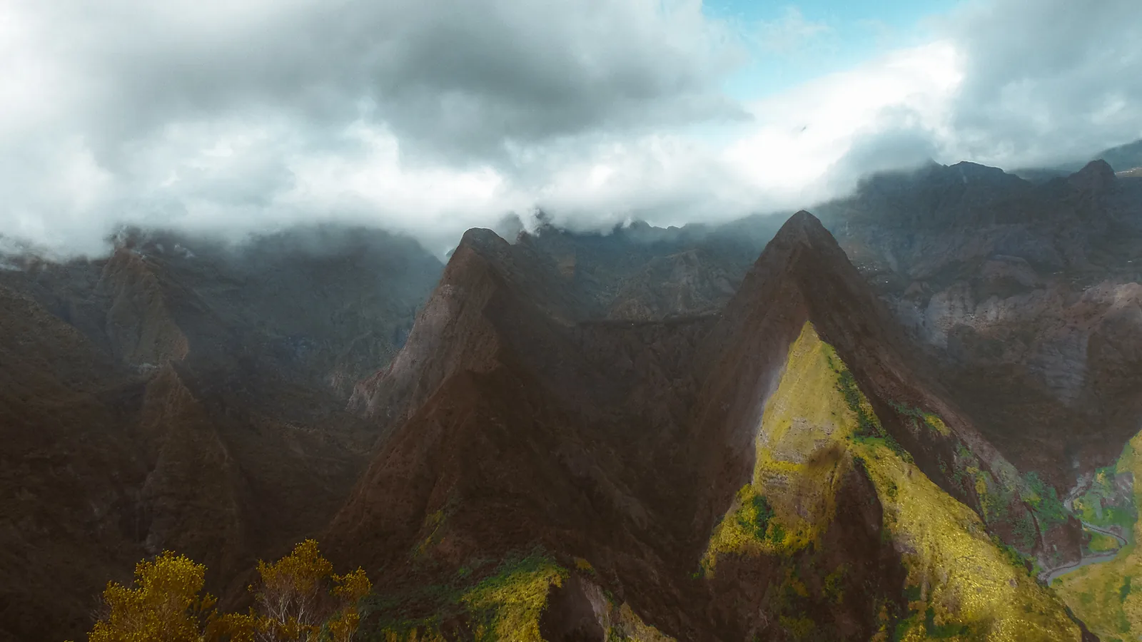 Jagged volcanic peaks rising through drifting cloud on Reunion Island, France