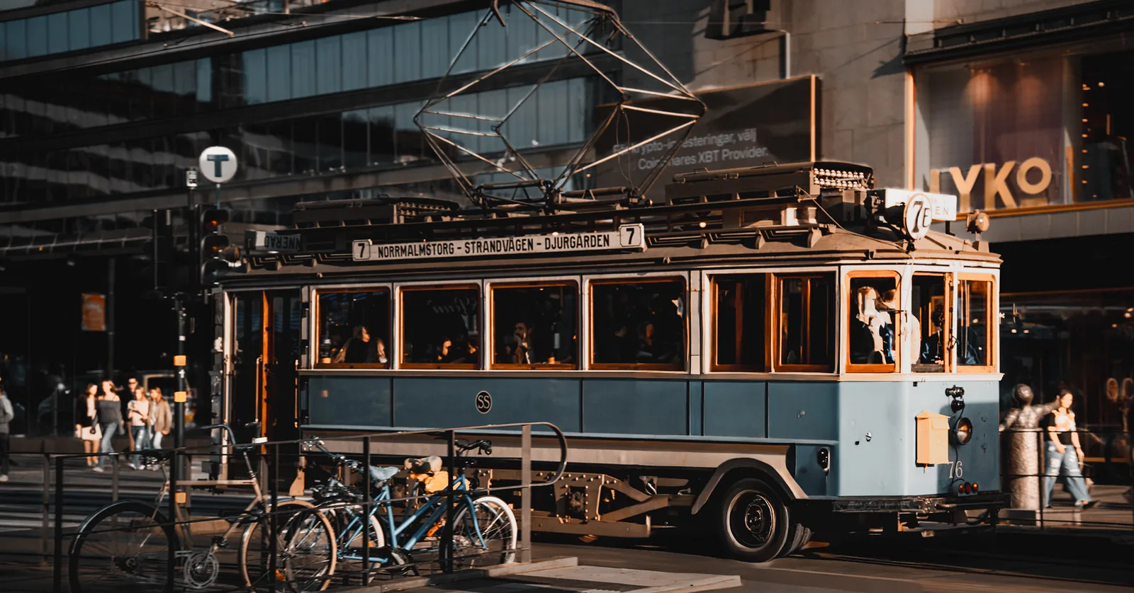 Vintage blue tram trundling down a sunlit city street in Sweden