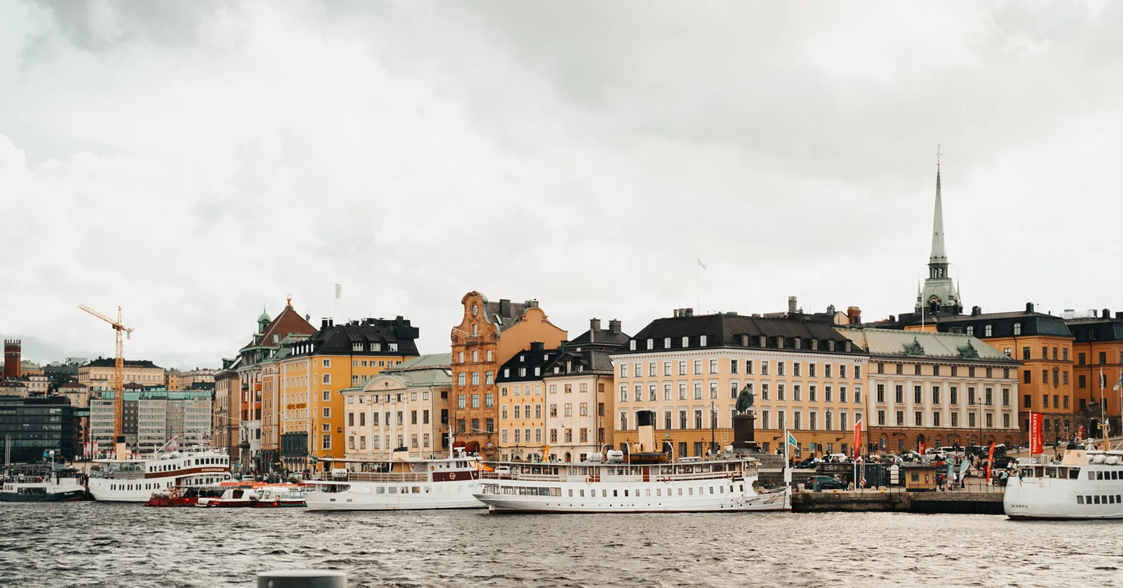 Colorful old-town waterfront buildings lining a busy harbor in Sweden