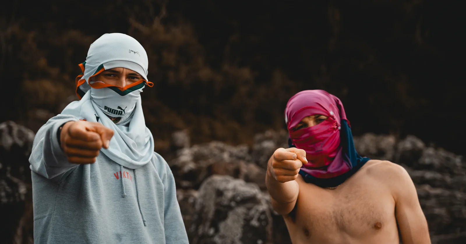 Two friends in playful face coverings pointing toward the camera in Sweden