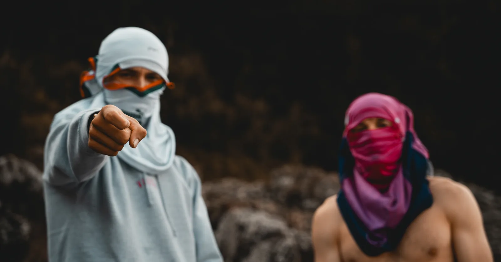 Friend in a patterned face covering pointing straight at the camera in Sweden