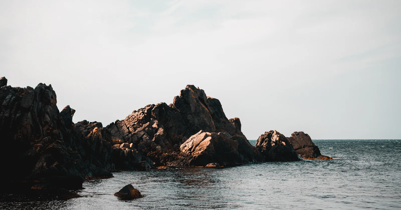 Jagged dark rock islets rising from calm coastal waters in Sweden