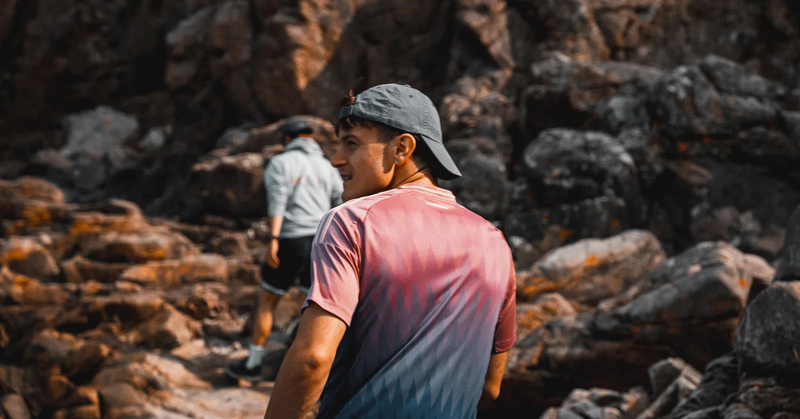 Friends hiking across sunlit boulders along the rugged Swedish coast